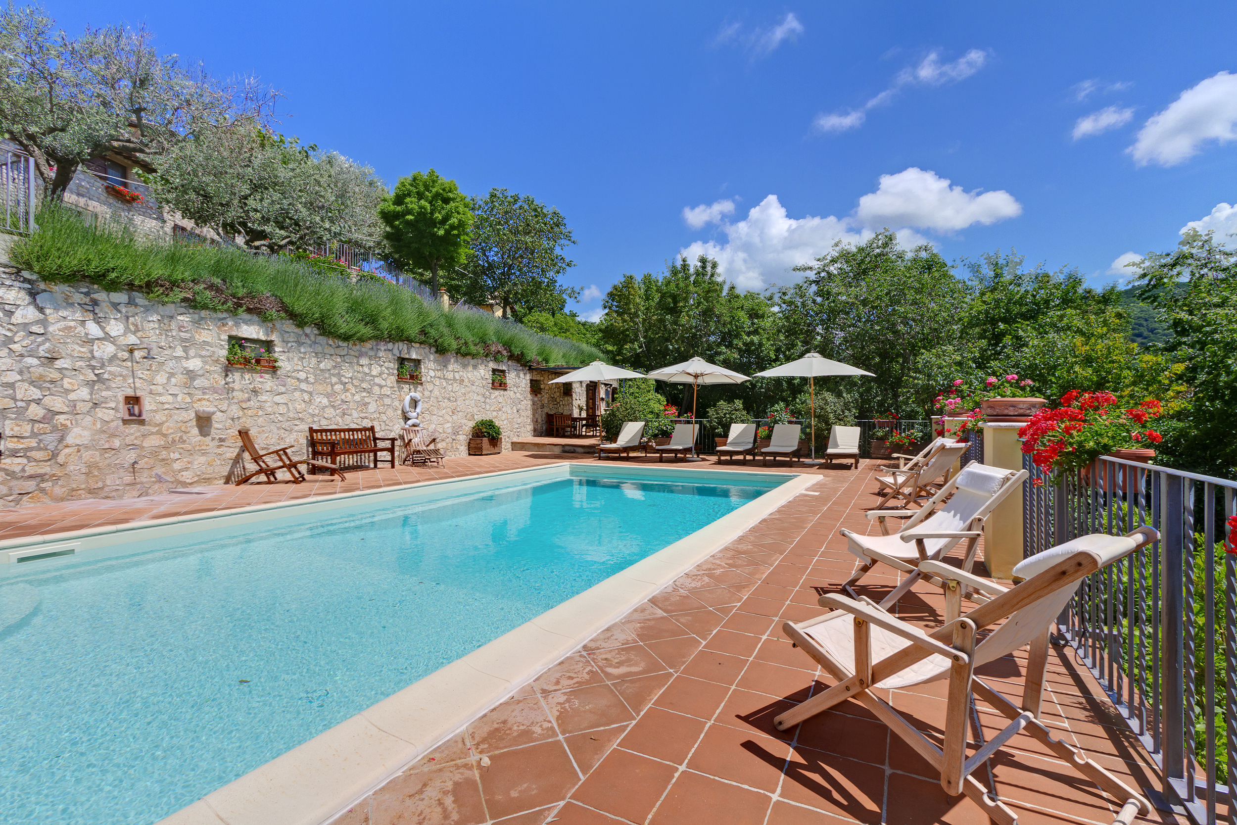 piscina panoramica con lettini, sdraio, ombrelloni e doccia borgo acquaiura